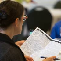 A staff member reads her event program.
